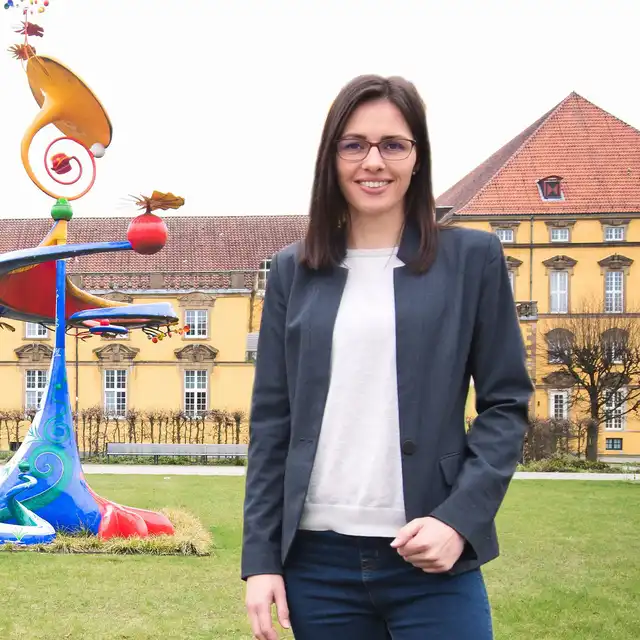 Kirstin Berger vor einem großen gelben Gebäude