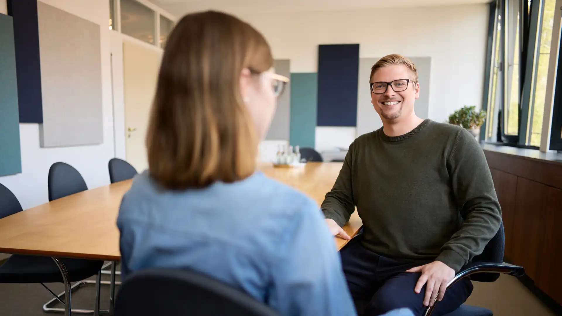 Ein Mann und eine Frau sitzen sich an einem Tisch gegenüber