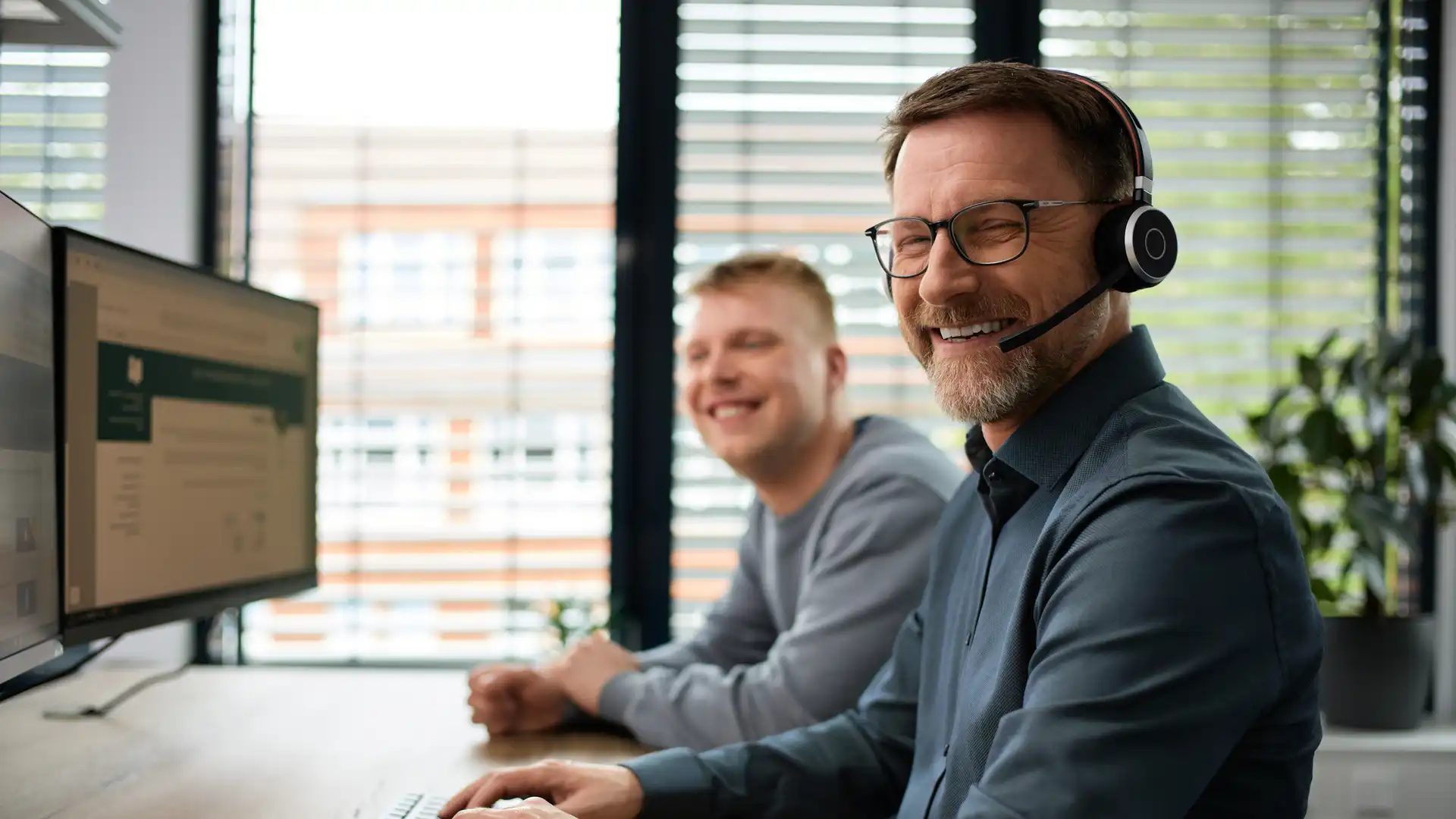 Mitarbeiter mit Headset vor dem PC